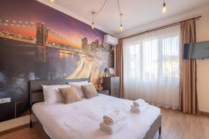 a bedroom with a large bed with towels on it at Amazing Location In The Center For 8 in Sofia