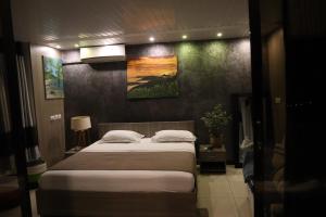 a bedroom with a bed and a painting on the wall at 180 Degrees Self-Catering in Victoria