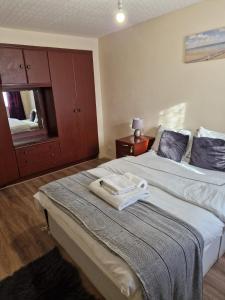 a bedroom with a large bed with a towel on it at Dagenham Contractors Favourite in Dagenham