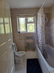 bagno con vasca, servizi igienici e finestra di Dagenham Contractors Favourite a Dagenham