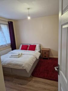 una camera da letto con un letto con cuscini rossi di Dagenham Contractors Favourite a Dagenham