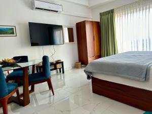 ネゴンボにあるOcean Breeze Hotel Residencies BritLanka Apartments Negomboのベッドルーム(ベッド1台、デスク、テレビ付)