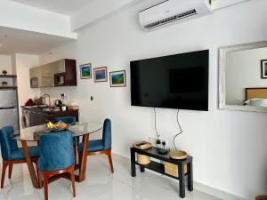 a living room with a table and a television on a wall at Ocean Breeze Hotel Residencies BritLanka Apartments Negombo in Negombo