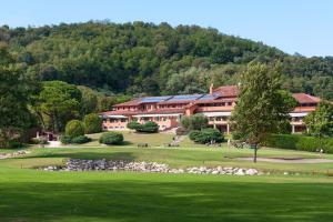 un gran edificio con un campo verde y árboles en Golf Club Padova - Relais Graya, en Galzignano Terme
