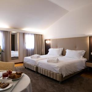 Habitación de hotel con 2 camas y mesa en Golf Club Padova - Relais Graya, en Galzignano Terme