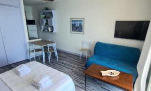 ein Wohnzimmer mit einem blauen Sofa und einem Tisch in der Unterkunft Studio pied dans l’eau CAP CORSE ERBALUNGA in Brando