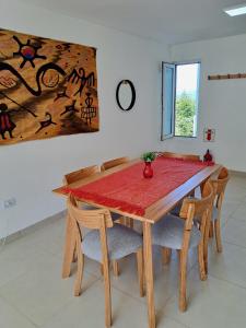 ein Esszimmer mit einem Tisch mit Stühlen und einem Gemälde in der Unterkunft Lo de Gaston in Ushuaia