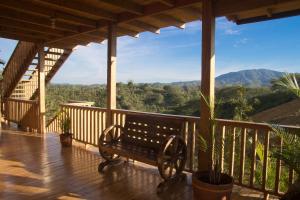 a bench on a porch with a view of the mountains at Villas Las Neblinas in Constanza