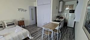 a bedroom with a bed and a table and a kitchen at Studio pied dans l’eau CAP CORSE ERBALUNGA in Brando