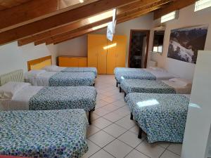una fila di letti in una stanza di Lunga Via Delle Dolomiti a Calalzo
