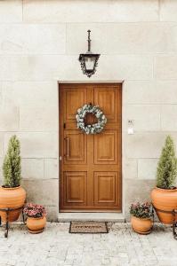 a wooden door with a wreath and two potted plants at Quinta Costa da Estrela in Gouveia