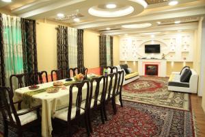 Yellow Hostel Dushanbe في دوسهانبي: غرفة طعام مع طاولة وكراسي ومدفأة