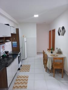 cocina con mesa y comedor con mesa en Apartamento para 6 pessoas bairro pereque mirim en Ubatuba