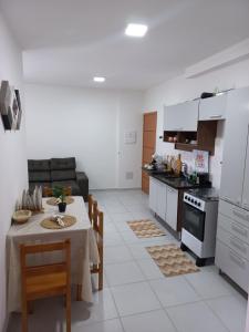 cocina y comedor con mesa, mesa y sillas en Apartamento para 6 pessoas bairro pereque mirim, en Ubatuba