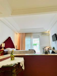 ein Wohnzimmer mit einem Bett und einem Tisch in der Unterkunft Superbe villa meublée Ennacer 95€/j in Burj at Turkī