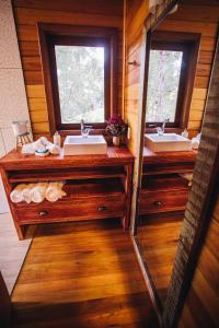 a bathroom with two sinks and two mirrors at Green Valley Refuge in Urubici