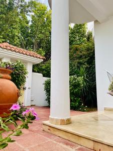 a porch with a white column and flowers at Superbe villa meublée Ennacer 95€/j in Burj at Turkī