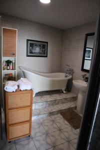 a bathroom with a bath tub and a sink at 180 Degrees Self-Catering in Victoria