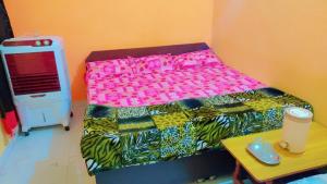 ein kleines Schlafzimmer mit einem Bett und einem Tisch in der Unterkunft Mahavir Home Stay in Ujjain