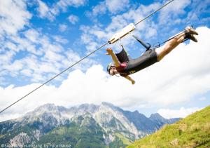 a person on a zip line in the mountains at KUCKUCK Leogang by we rent, Saalfelden Leogang Card included in Leogang