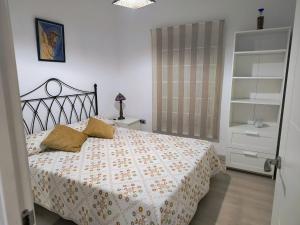 1 dormitorio con 1 cama con colcha de flores en Casa El limonero, en Sevilla