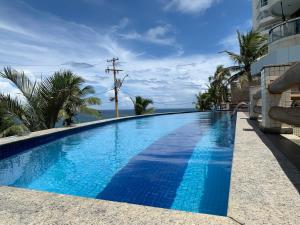 a large blue swimming pool next to a building at Apartamento no Rio Vermelho - Bairro Boêmio de Salvador in Salvador