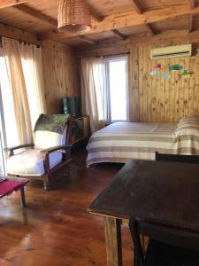ティグレにあるCabaña Isla Cocoのベッドルーム1室(ベッド1台、椅子1脚付)