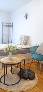 ein Wohnzimmer mit einem Tisch und einem Bett in der Unterkunft Petite touche douceur - studio avec parking et terrasse in Suresnes