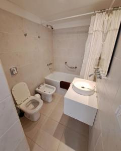 ein Badezimmer mit einem WC, einem Waschbecken und einer Badewanne in der Unterkunft Lo de Gaston in Ushuaia