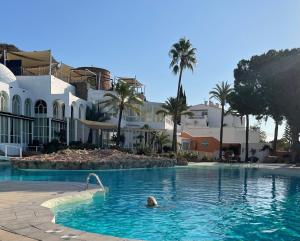 a person in the swimming pool at a resort at Lovely studio Nerja ground floor in Nerja