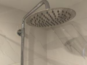 a shower with a shower head in a bathroom at Apollonas - 1BR Lux Apartment - Tsimiski Ladadika - Explore Center by foot - Close to Aristotelous square in Thessaloniki