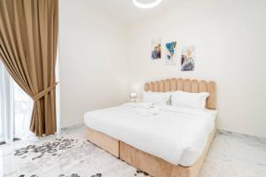 a bedroom with a large bed with white sheets and pillows at Spacious One Bedroom Apartment in Dubai