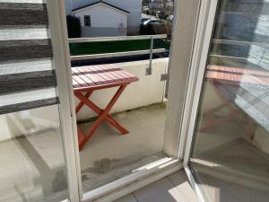 a bench sitting on a balcony next to a window at Appartement t2 cosy arrivée autonome in Vayres