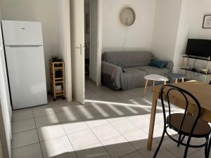 a living room with a couch and a refrigerator at Appartement t2 cosy arrivée autonome in Vayres