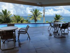 a patio with tables and chairs and a view of the ocean at Apartamento no Rio Vermelho - Bairro Boêmio de Salvador in Salvador