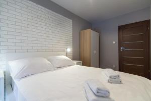 a bedroom with a white bed with towels on it at Apartament Great koło opery i miejscem postojowym w garażu in Białystok