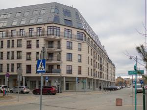 a large white building on a street with cars parked outside at Apartament Great koło opery i miejscem postojowym w garażu in Białystok