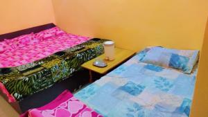 um pequeno quarto com uma cama e uma mesa em Mahavir Home Stay em Ujaim