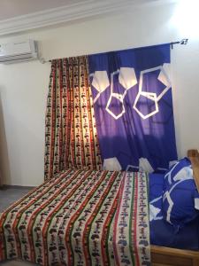 um quarto com uma cama com uma colcha colorida em Fafape em Lomé