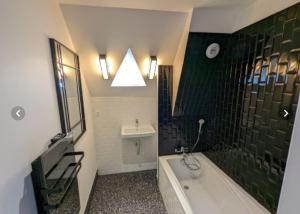 ein Badezimmer mit einer Badewanne und einem Waschbecken in der Unterkunft Grand appartement renové centre historique proche plages in Perros-Guirec