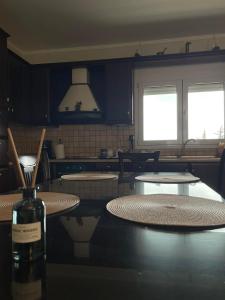 a kitchen with two tables and a bottle of wine at Athina's House in Xanthi