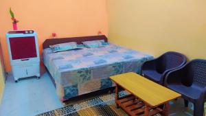 Schlafzimmer mit einem Bett, einem Tisch und Stühlen in der Unterkunft Mahavir Home Stay in Ujjain