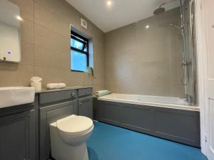 a bathroom with a toilet and a tub and a sink at Bright & Spacious Edwardian Townhouse with Garden in Truro