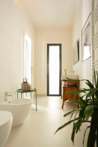 un bagno con vasca bianca e pianta di Dèpendance - Lequile - Alfa Country House a Lequile