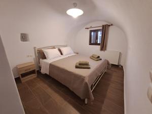 a bedroom with a bed in a white room at Old Village apartments in Kýthira