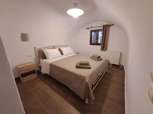 a bedroom with a bed in a white room at Old Village apartments in Kythira