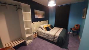 1 dormitorio con cama y estante para libros en AGAPANTHE, en Saint-Georges-lès-Baillargeaux