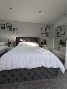 a bedroom with a large bed with white sheets at Room in Detached Annex in Cantley