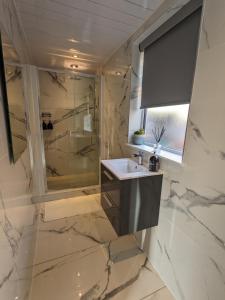 a bathroom with a sink and a shower at Room in Detached Annex in Cantley