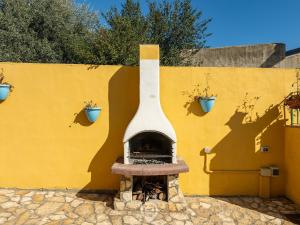 una chimenea frente a una pared amarilla con macetas en Casa Tulipano, en Pula